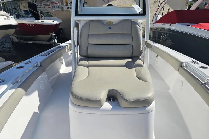 Slide: The Image of 2021 Sportsman Masters 267OE Bay Boat with cushioned seating in a marina setting. - 13