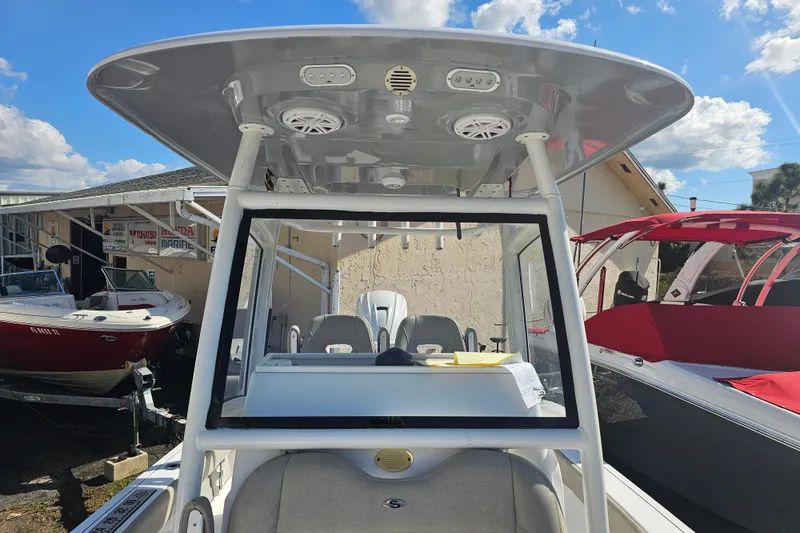 Slide: The Image of 2021 Sportsman Masters 267OE Bay Boat with T-top and console, displayed outdoors. - 14