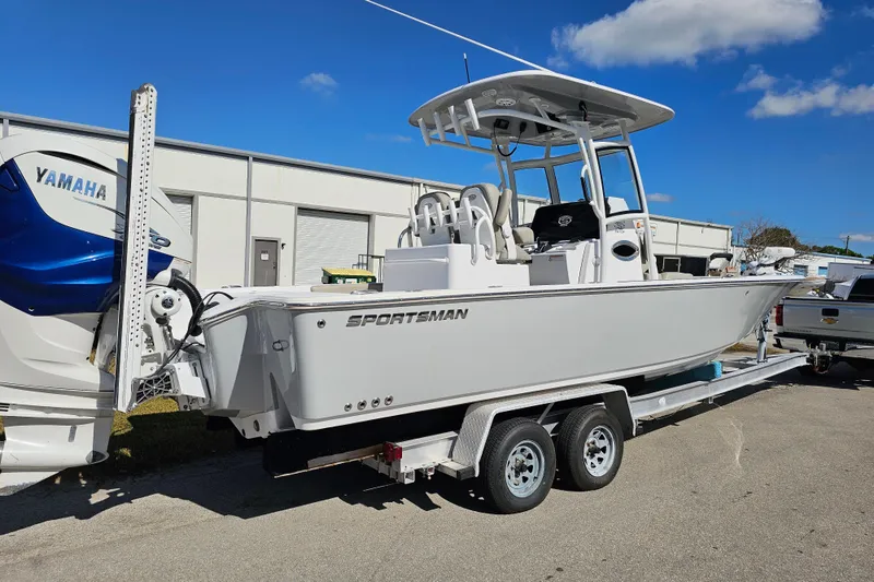 Slide: The Image of 2021 Sportsman Masters 267OE Bay Boat on trailer, featuring Yamaha engine, parked outdoors. - 2