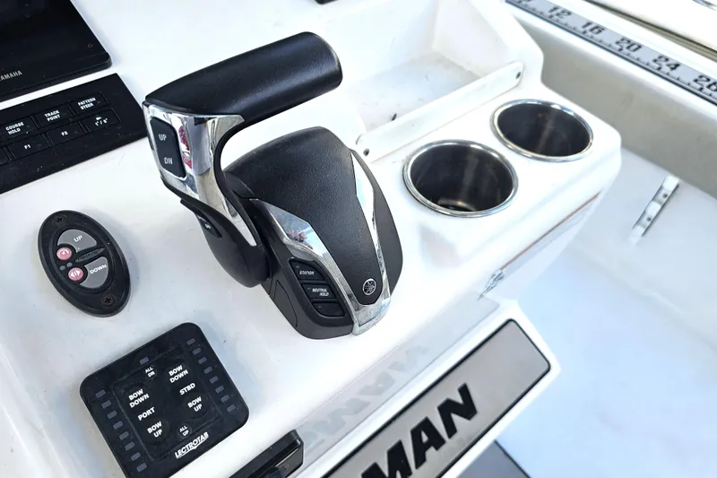 Slide: The Image of 2021 Sportsman Masters 267OE Bay Boat control panel with throttle and cup holders. - 21