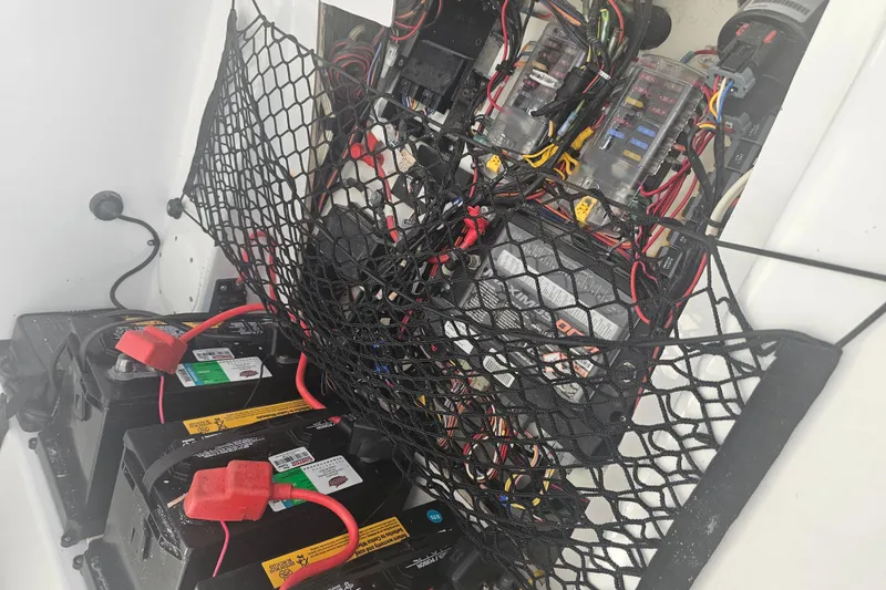 Slide: The Image of 2021 Sportsman Masters 267OE Bay Boat battery compartment with wiring and netting. - 33