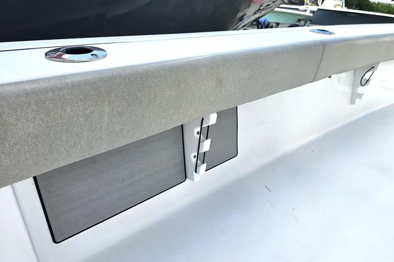 Slide: The Image of 2021 Sportsman Masters 267OE Bay Boat interior detail with rod holders and cushioned side panel. - 36