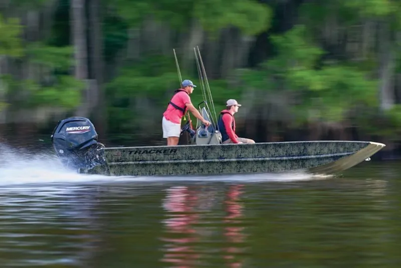 Slide: The Image of 2026 Tracker Grizzly 1860 Center Console boat speeding on a river with two passengers. - 8