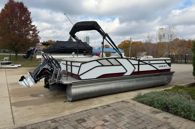 Slide: The Image of 2021 Crest Caribbean LX 230 SLC pontoon boat with covered seating, parked on driveway. - 4