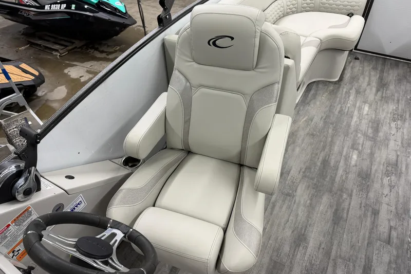 Slide: The Image of 2021 Crest Caribbean LX 230 SLC boat interior with captain's chair and control panel. - 8