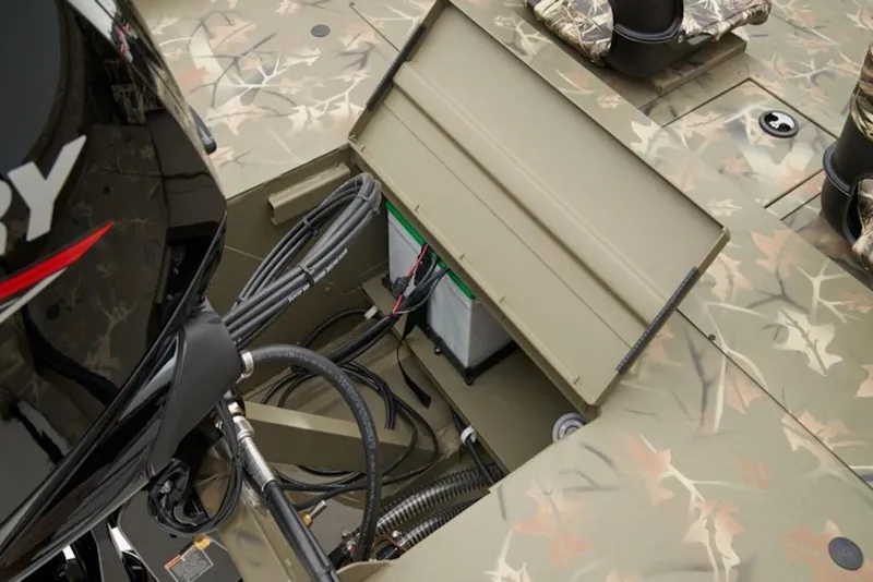 Slide: The Image of 2026 Tracker Grizzly 1754 SC boat interior with camo design and engine compartment. - 14