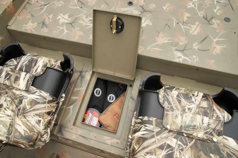 Slide: The Image of 2026 Tracker Grizzly 1754 SC boat interior with camo seats and storage compartment. - 16