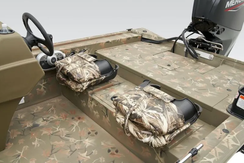 Slide: The Image of 2026 Tracker Grizzly 1754 SC boat interior with camouflage seating and steering console. - 4