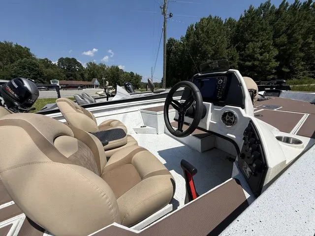 Slide: The Image of 2023 Xpress Boats H17C interior with steering wheel and seating, under clear blue sky. - 4