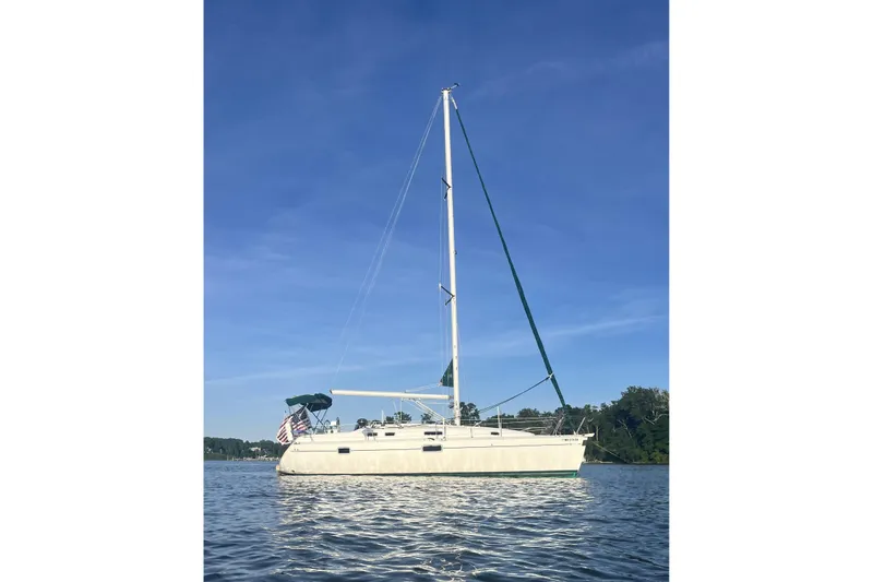 The Image of 1995 Beneteau Oceanis 351 sailboat on calm water under clear blue sky. - 0