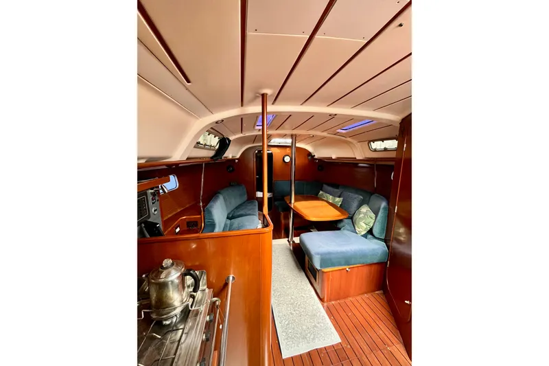 Slide: The Image of Interior of 1995 Beneteau Oceanis 351 sailboat with cozy seating and wooden finishes. - 10