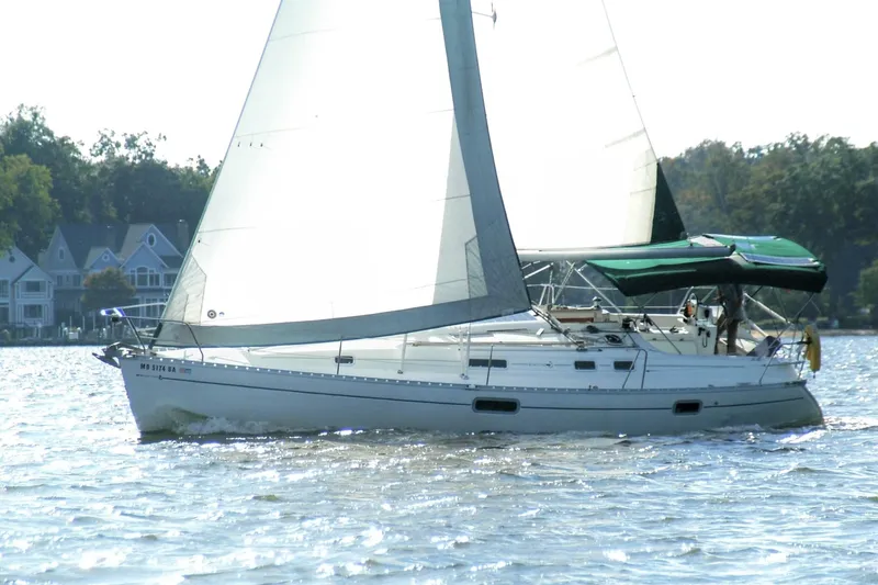 Slide: The Image of 1995 Beneteau Oceanis 351 sailboat cruising on a sunny day near waterfront homes. - 4