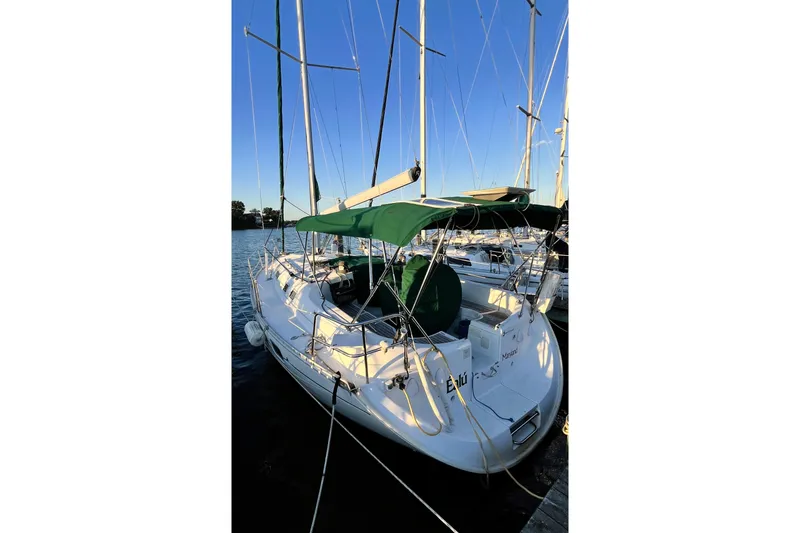 Slide: The Image of 1995 Beneteau Oceanis 351 sailboat docked with green canopy and clear blue sky. - 9