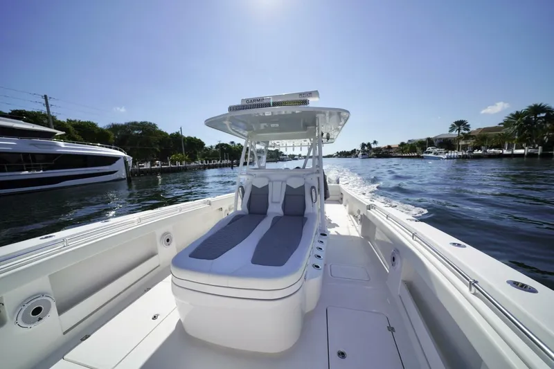 Slide: The Image of 2024 Invincible 35 Catamaran with covered console, docked near palm trees and waterfront homes. - 11