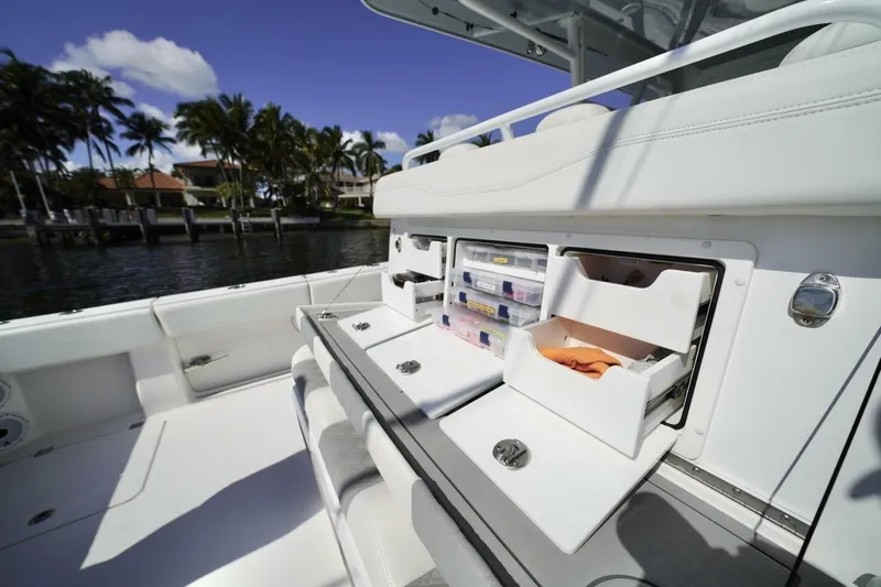 Slide: The Image of Open storage compartment on 2024 Invincible 35 Catamaran, featuring organized tackle boxes. - 23
