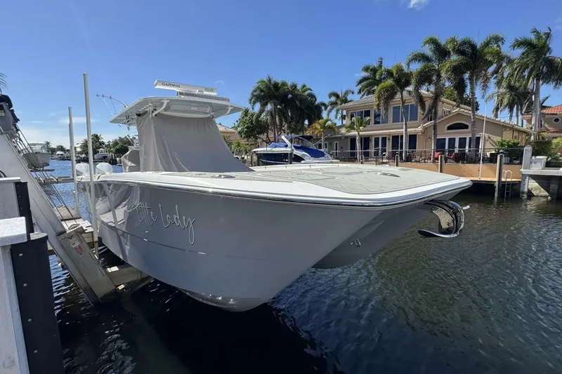 Slide: The Image of 2024 Invincible 35 Catamaran cruising near a lighthouse and beachfront cityscape. - 31
