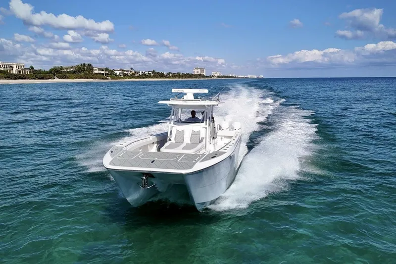 Slide: The Image of 2024 Invincible 35 Catamaran cruising on clear blue ocean under a sunny sky. - 33