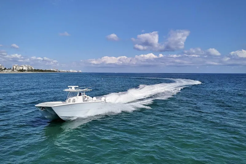 Slide: The Image of 2024 Invincible 35 Catamaran cruising on ocean near tropical coastline. - 35