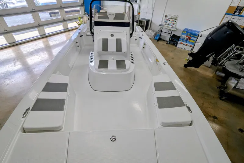 Slide: The Image of 2026 Frontier 2104 boat interior with seating and console in showroom. - 13