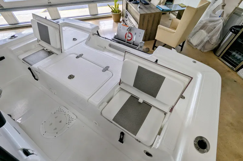 Slide: The Image of 2026 Frontier 2104 boat interior with seating and storage compartments in showroom. - 18