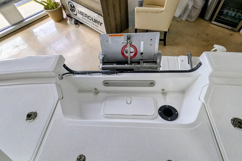 Slide: The Image of 2026 Frontier 2104 boat interior with Mercury equipment, featuring storage compartments and seating area. - 23