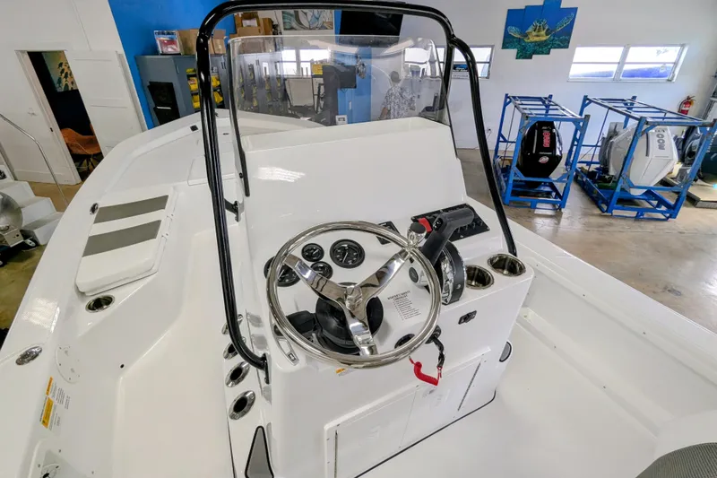 Slide: The Image of 2026 Frontier 2104 boat interior with steering wheel and control panel in showroom. - 7