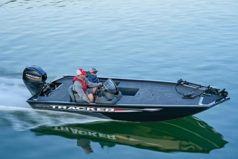 Slide: The Image of 2025 Tracker Pro 170 boat cruising on calm water with two passengers. - 7