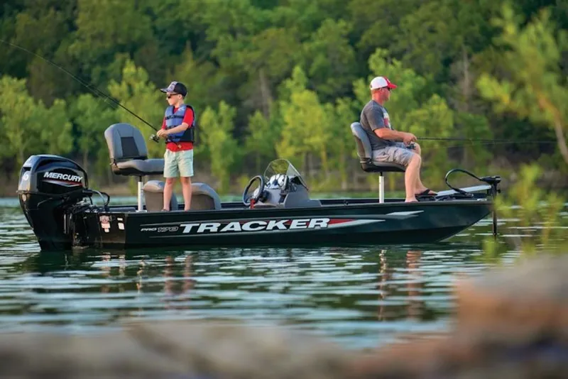 Slide: The Image of 2025 Tracker Pro 170 boat with two people fishing on a serene lake. - 8