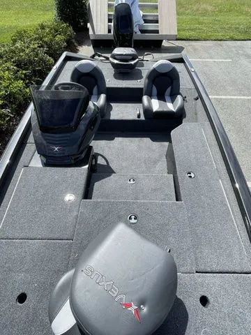 Slide: The Image of 2023 Vexus AVX181 boat interior with seating and console, parked outdoors. - 10