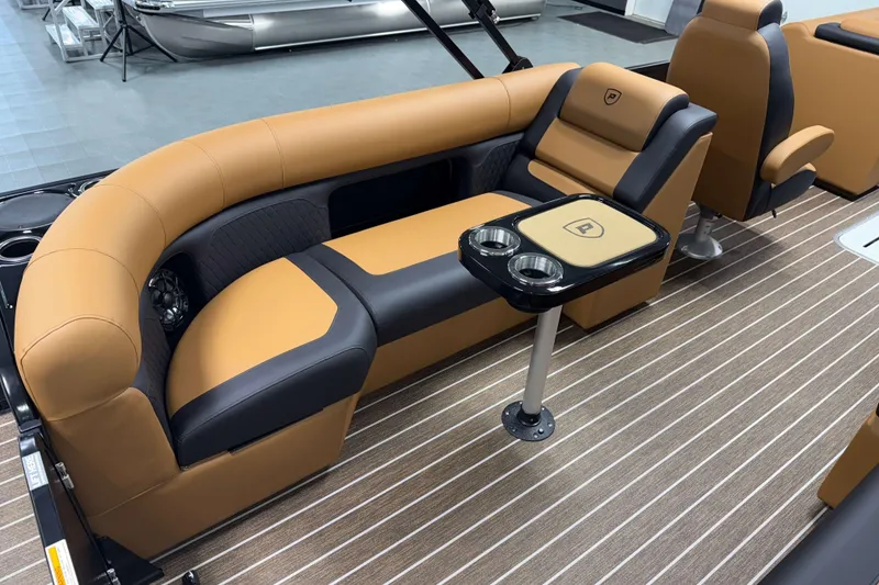 Slide: The Image of 2026 Premier 230 SunSation RF Tritoon interior with tan and black seating, cup holders, and striped flooring. - 10