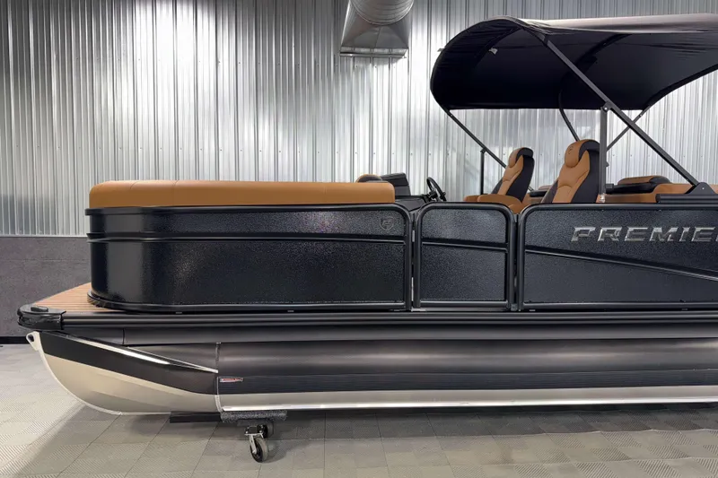 Slide: The Image of 2026 Premier 230 SunSation RF Tritoon in showroom, sleek black design, luxury seating. - 4