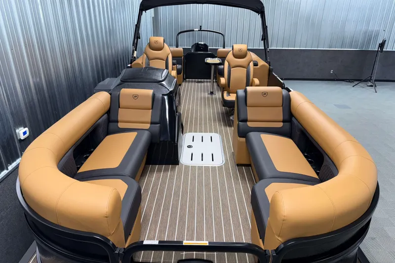 Slide: The Image of 2026 Premier 230 SunSation RF Tritoon with luxurious tan and black seating, indoor display. - 7