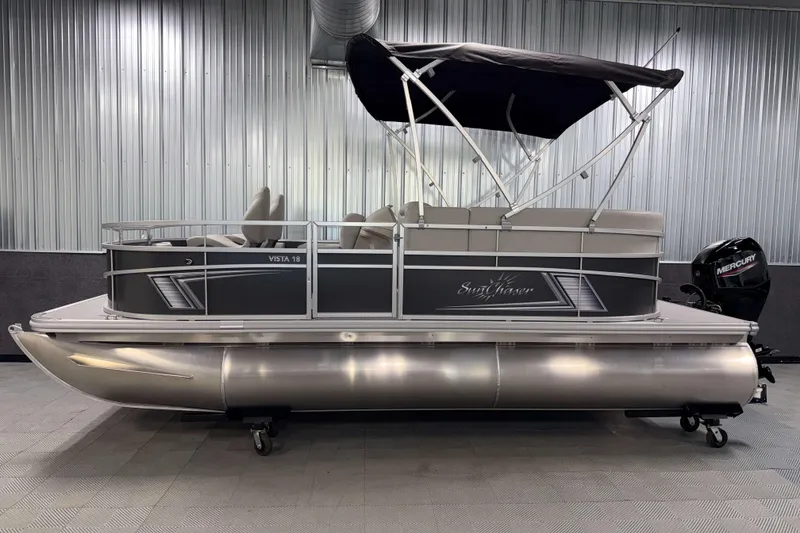 Slide: The Image of 2026 SunChaser Vista 18 Fish pontoon boat with canopy in a showroom setting. - 20