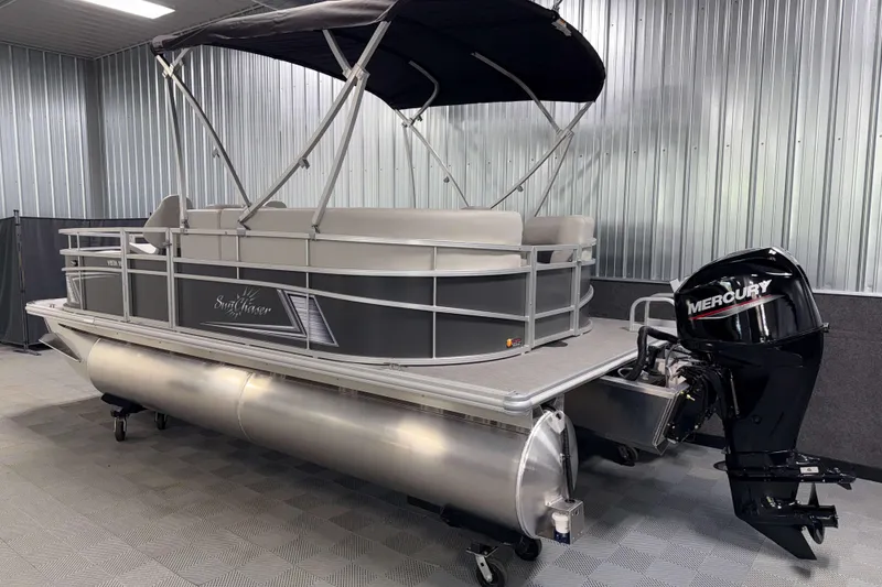 Slide: The Image of 2026 SunChaser Vista 18 Fish pontoon boat with Mercury outboard motor in a showroom. - 21