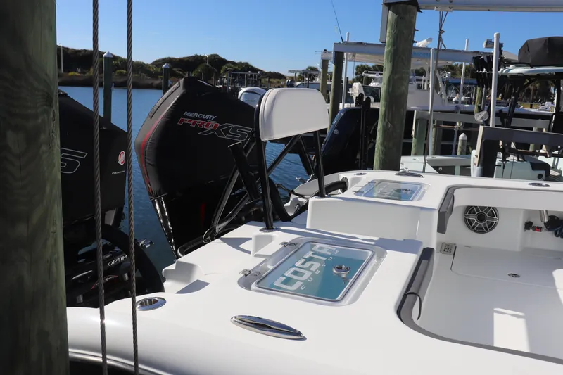 Slide: The Image of Open storage compartment on 2021 Costa Custom Boats 26, featuring multiple rod holders. - 18