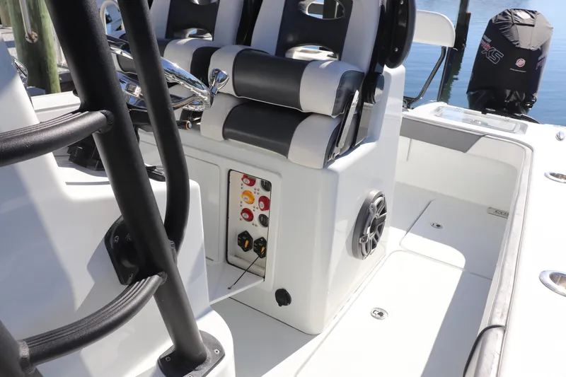 Slide: The Image of Open storage compartment on 2021 Costa Custom Boats 26, featuring cup holders and various items inside. - 27