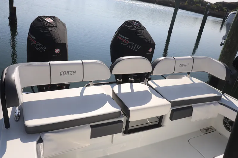 Slide: The Image of 2021 Costa Custom Boats 26 with dual Mercury engines, docked on calm water. - 3