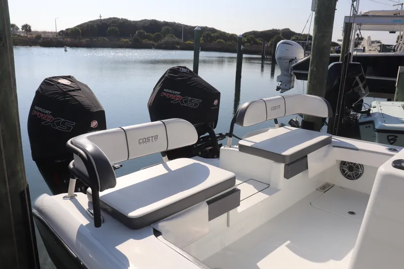 Slide: The Image of 2021 Costa Custom Boats 26 with dual Mercury Pro XS engines docked by the water. - 4