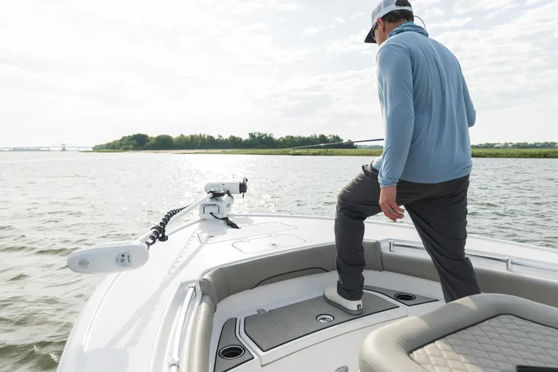Slide: The Image of 2024 Sportsman Masters 247 Bay Boat cockpit with steering wheel and controls, docked by waterfront. - 5
