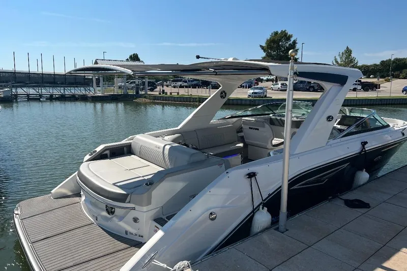 The Image of 2020 Sea Ray SLX 310 boat docked at a marina under clear blue skies. - 0