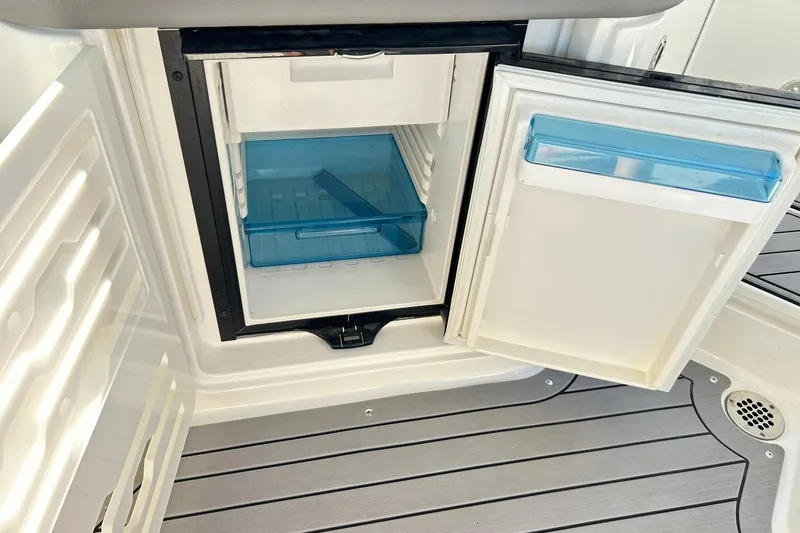Slide: The Image of Open mini fridge on 2020 Sea Ray SLX 310 boat, featuring blue storage compartments. - 20