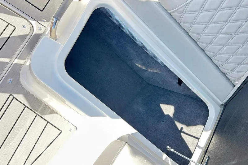 Slide: The Image of Storage compartment on 2020 Sea Ray SLX 310 boat with cushioned seating and carpeted interior. - 25