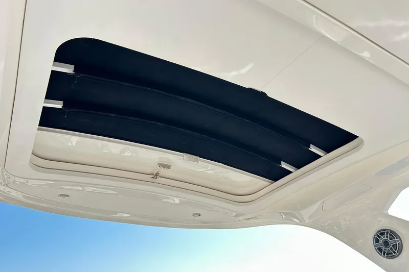 Slide: The Image of 2020 Sea Ray SLX 310 boat sunroof, open with blue sky background. - 29