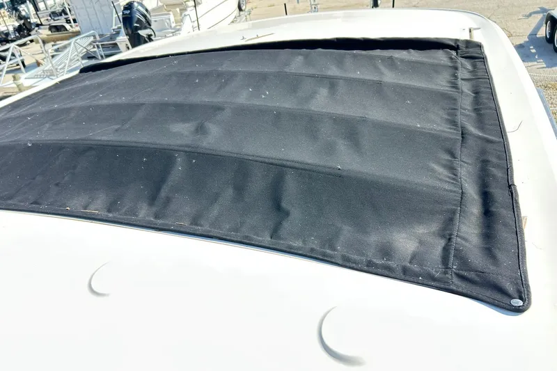 Slide: The Image of 2020 Sea Ray SLX 310 boat with black canvas cover on deck. - 33