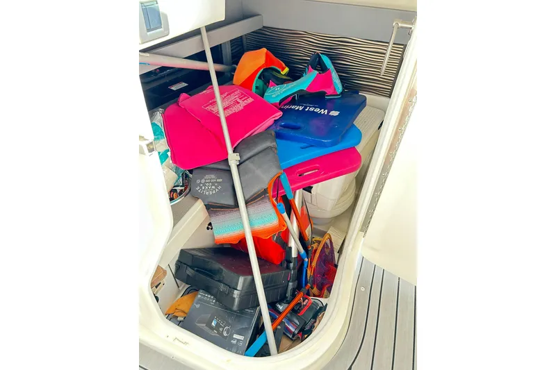 Slide: The Image of Storage compartment of 2020 Sea Ray SLX 310 filled with colorful boating gear. - 39