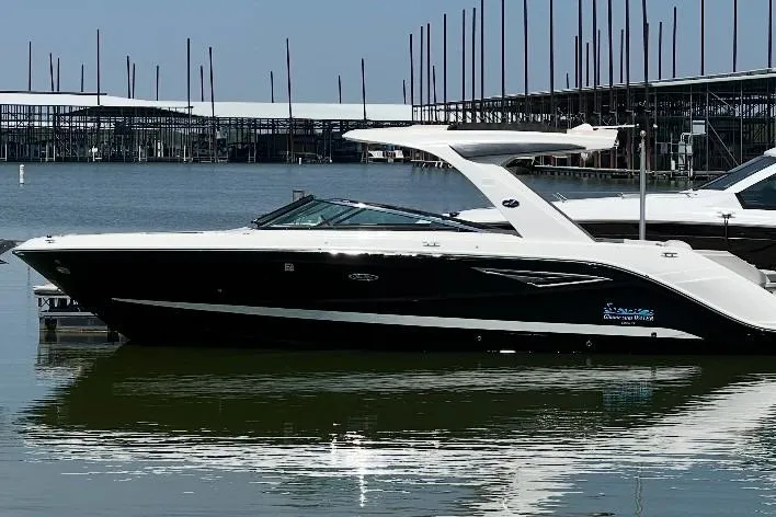 Slide: The Image of 2020 Sea Ray SLX 310 boat docked at marina, calm water reflection. - 43