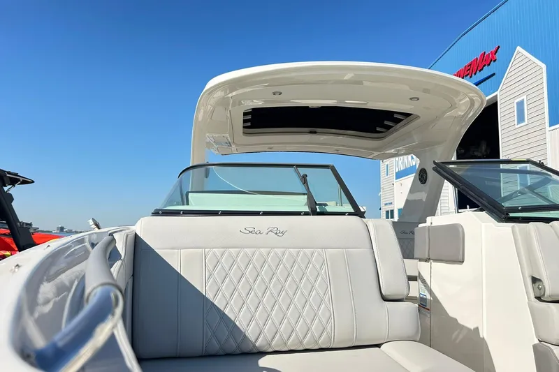 Slide: The Image of 2020 Sea Ray SLX 310 boat with luxurious seating and open deck under clear blue sky. - 8