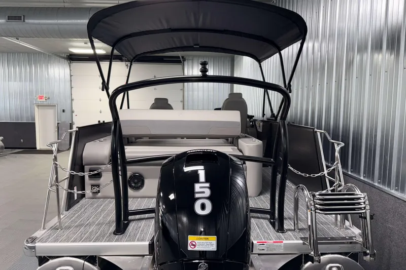 Slide: The Image of 2026 Premier 230 Sunsation RL Tritoon with 150 HP engine in a metal-walled showroom. - 6