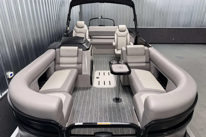 Slide: The Image of 2026 Premier 230 Sunsation RL Tritoon with luxurious seating and modern design in a showroom. - 7