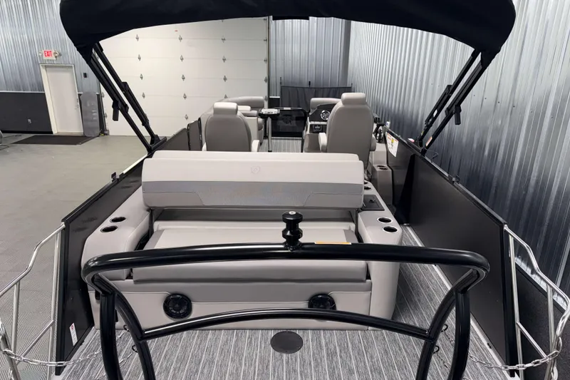 Slide: The Image of 2026 Premier 230 Sunsation RL Tritoon interior with seating and steering console in a showroom. - 8